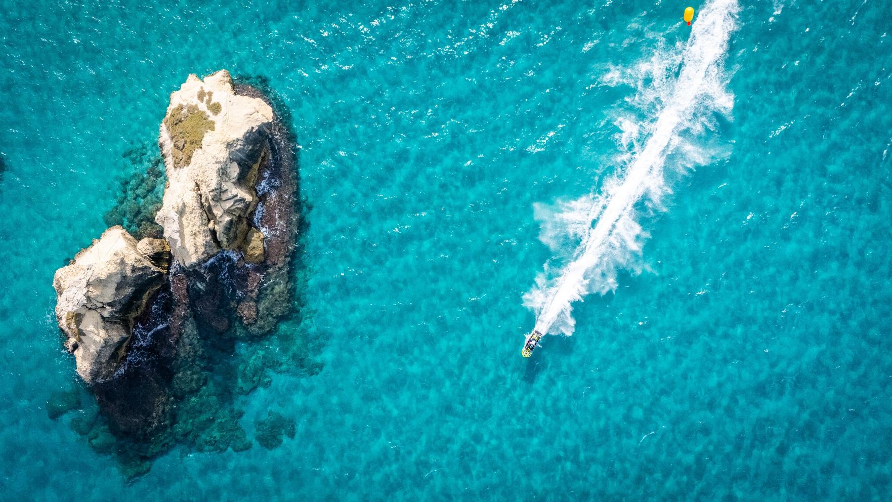 Aquabike category gold winner: an aquabike at speed over turquoise water near a rock formation at Torre dell'Orso, Italy