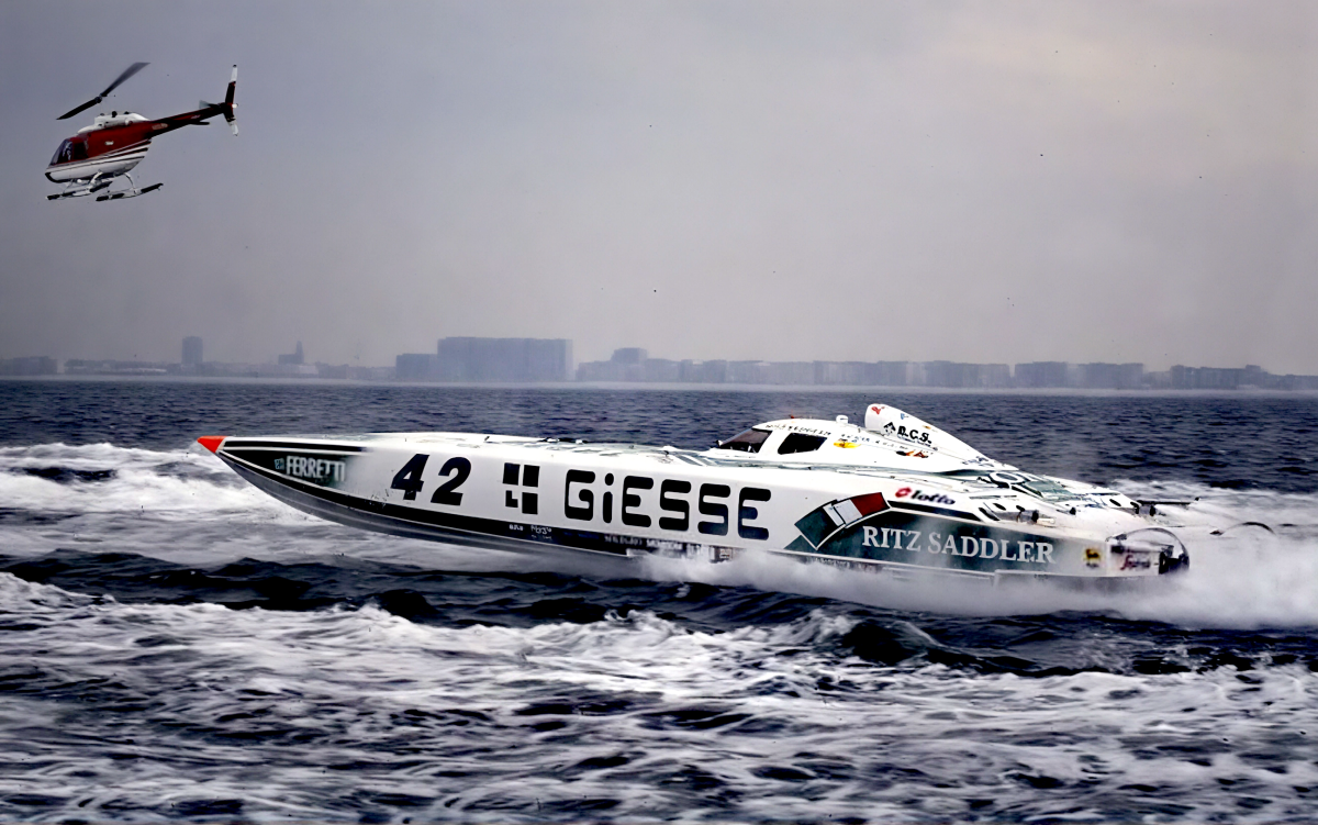 Giesse Philosophy Class 1 catamaran number 42 racing at speed with helicopter overhead, 1994 World Championship