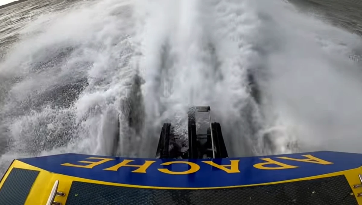 Apache 555 at speed during sea trials, viewed from astern, showing surface-piercing drive system and rooster tail