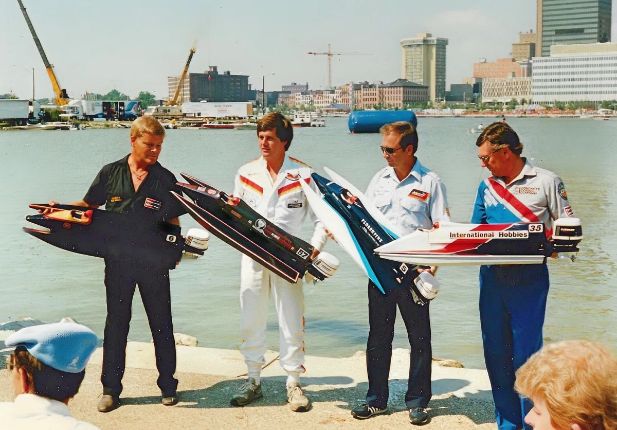 From left, Rick Frost, Ben Robertson, Gene Thibodaux and Barry Woods hold AMPS scale model replicas at a US race venue