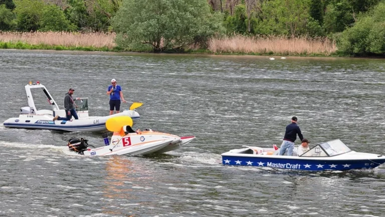 Boat 5 Team Autovision escorted from the circuit by safety boats after retiring in hour seven of Race 1 at the 24 Heures Motonautiques de Normandie 2026, Poses