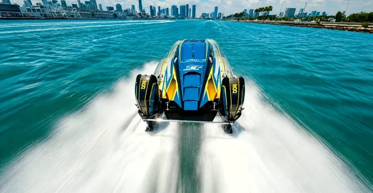 Blue and yellow IHRA powerboat with twin MOD X engines at speed on Biscayne Bay with Miami skyline