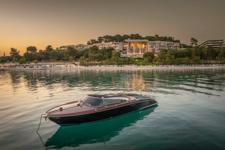 A Riva luxury boat moored at sunset, one of the iconic brands within the Ferretti Group portfolio