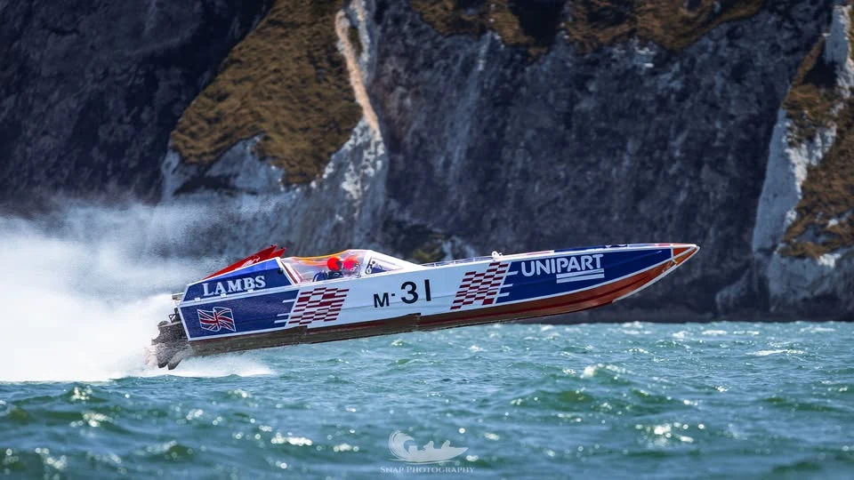 Unipart (M-31) airborne off the Needles during the MDL Marinas Ocean Village Cup