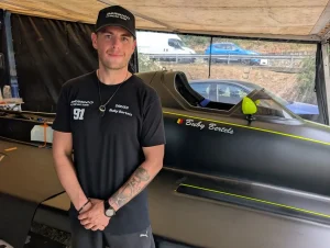 Buby Bertels in Bernico F2 Racing Team kit beside his number 91 F2 boat at Viverone, with his name and the Belgian flag on the hull
