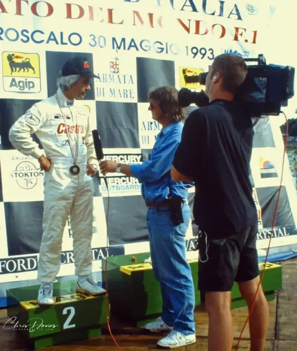 Eric Michell of FM Television interviews a driver on the podium in Italy, 1993