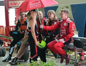 Andre Solvang with the Sharjah Team at Viverone, sheltering Mathilda Wiberg under the team umbrella