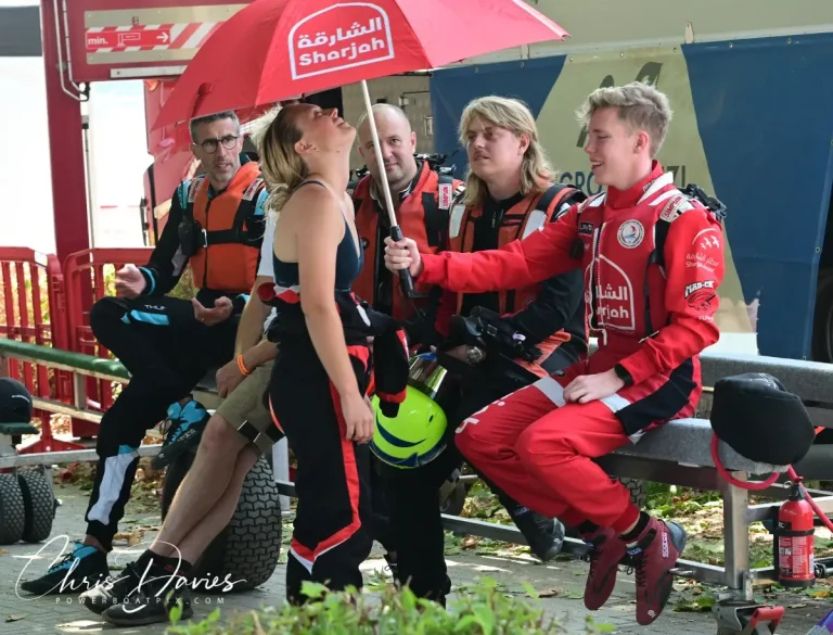 Andre Solvang with the Sharjah Team at Viverone, sheltering Mathilda Wiberg under the team umbrella