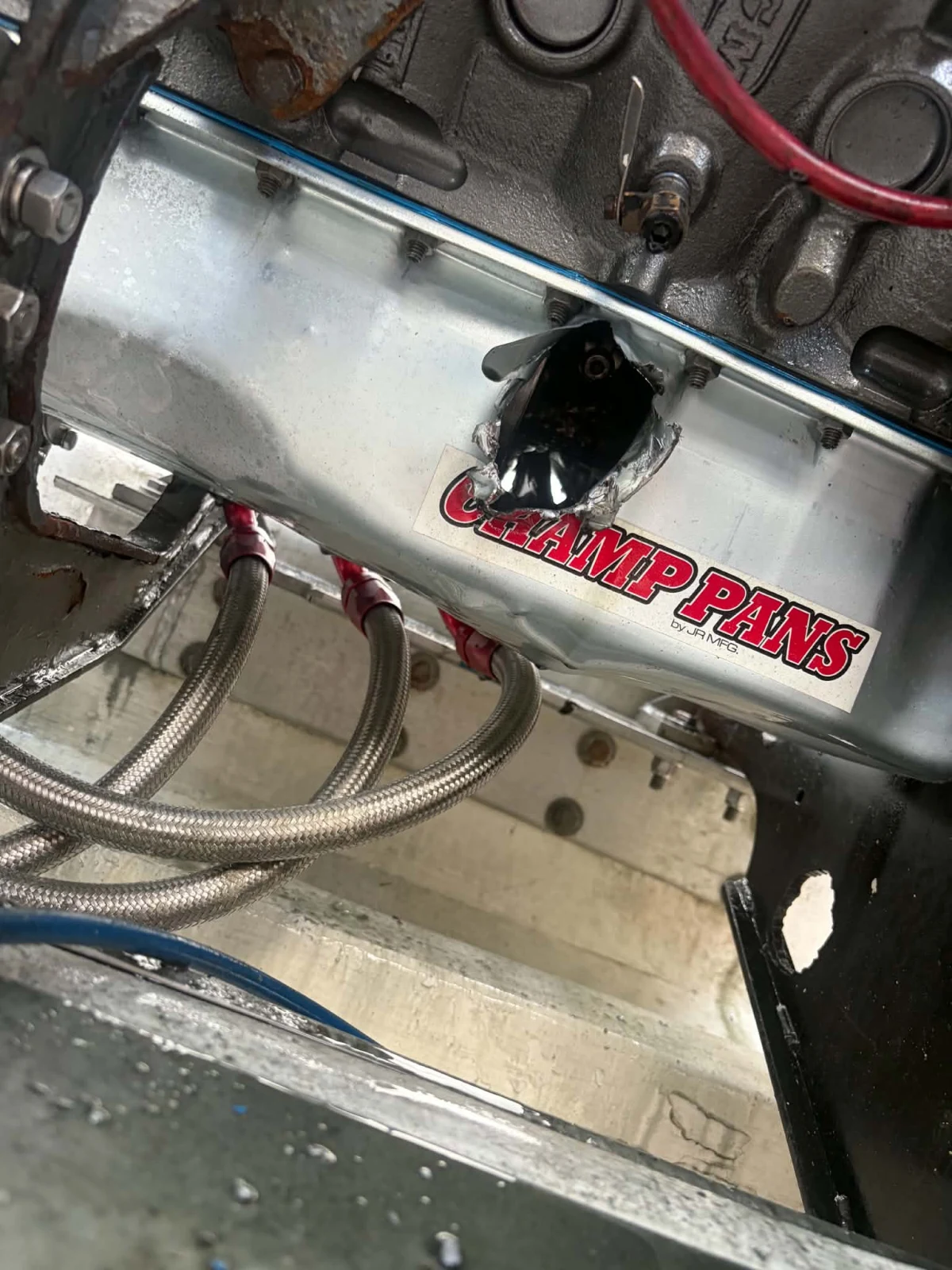 Champ Pans oil sump on a race boat engine with a jagged hole punched through its side