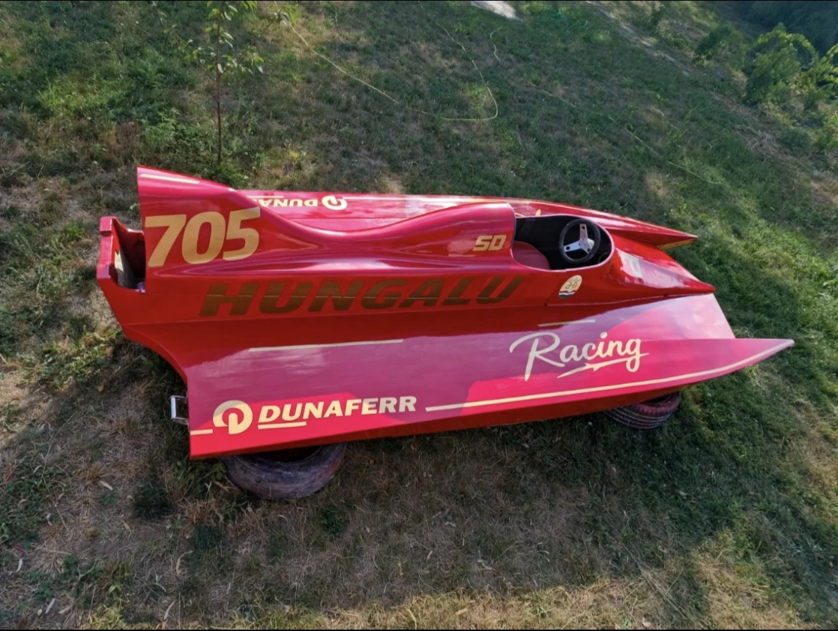 1980s wooden racing boat in red Hungalu Racing and Dunaferr livery, race number 705