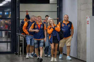Edgaras Riabko and his team, in orange and blue team kit, walking through arrivals at Kaunas Airport after winning the 2026 UIM F2 World Championship