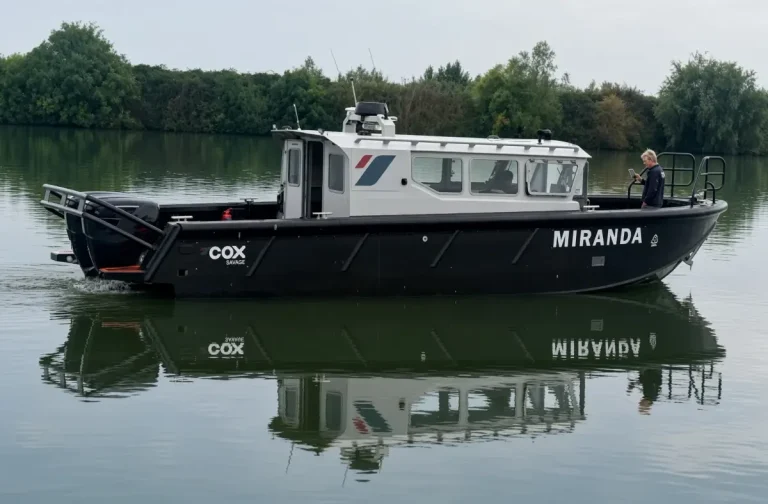 Cox Marine test and development vessel Miranda, a black Tideman RBC1200 HDPE workboat with white wheelhouse and twin Cox Marine V8 diesel outboards