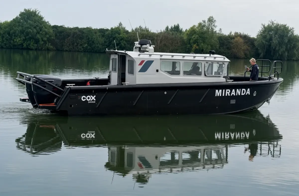 Cox Marine test and development vessel Miranda, a black Tideman RBC1200 HDPE workboat with white wheelhouse and twin Cox Marine V8 diesel outboards