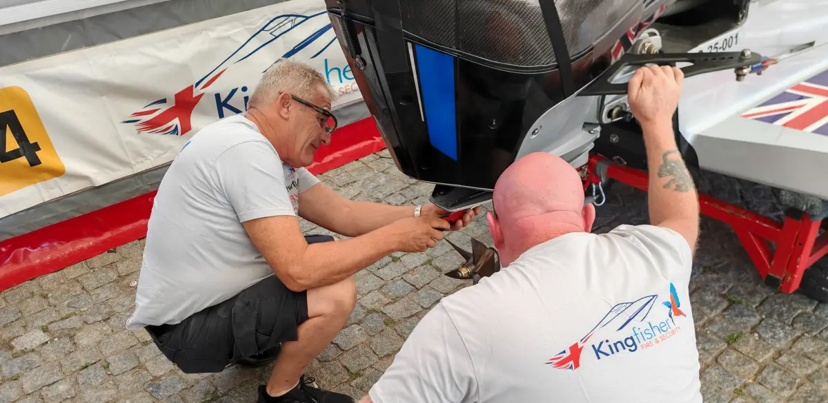 Ian Blacker crouching beside his UIM F2 boat in the pits, fitting a five-bladed DMLS propeller to the gearcase