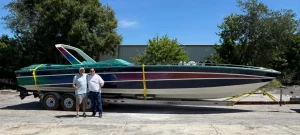 Lady Vice, a 1986 Wellcraft Scarab 377 in Miami Vice colours, on a trailer with two men standing alongside